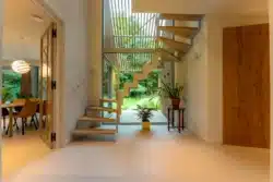 Lichte entree met open trap en doorkijk naar de tuin van de duurzame woning in Berkum.
