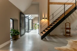 Hal met open trap en doorkijk; een eigentijdse indeling binnen de karakteristieke boerderij in Okkenbroek.