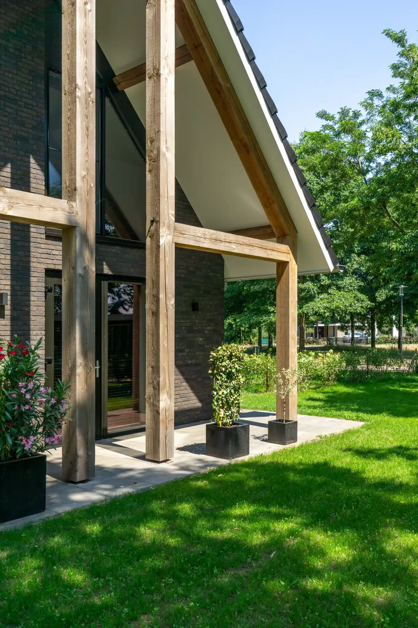 Houten gebinten en grote raampartij aan de zijkant van de woning in Wesepe.