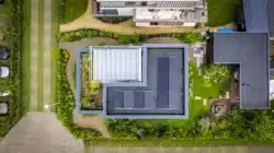 Luchtfoto van de nieuwbouwwoning in Deventer met zonnepanelen en groene tuin.