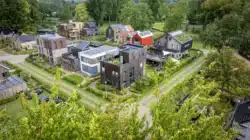 Luchtfoto van de wijk in Deventer met moderne woningen, groene daken en houten gevels.