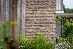 Close-up van het metselwerk en de houten gevel van de nieuwbouwwoning in Deventer.