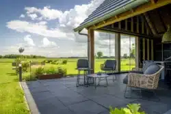 Overkapping met zithoek en vrij uitzicht over het Sallandse landschap, onderdeel van schuurwoning in Olst.