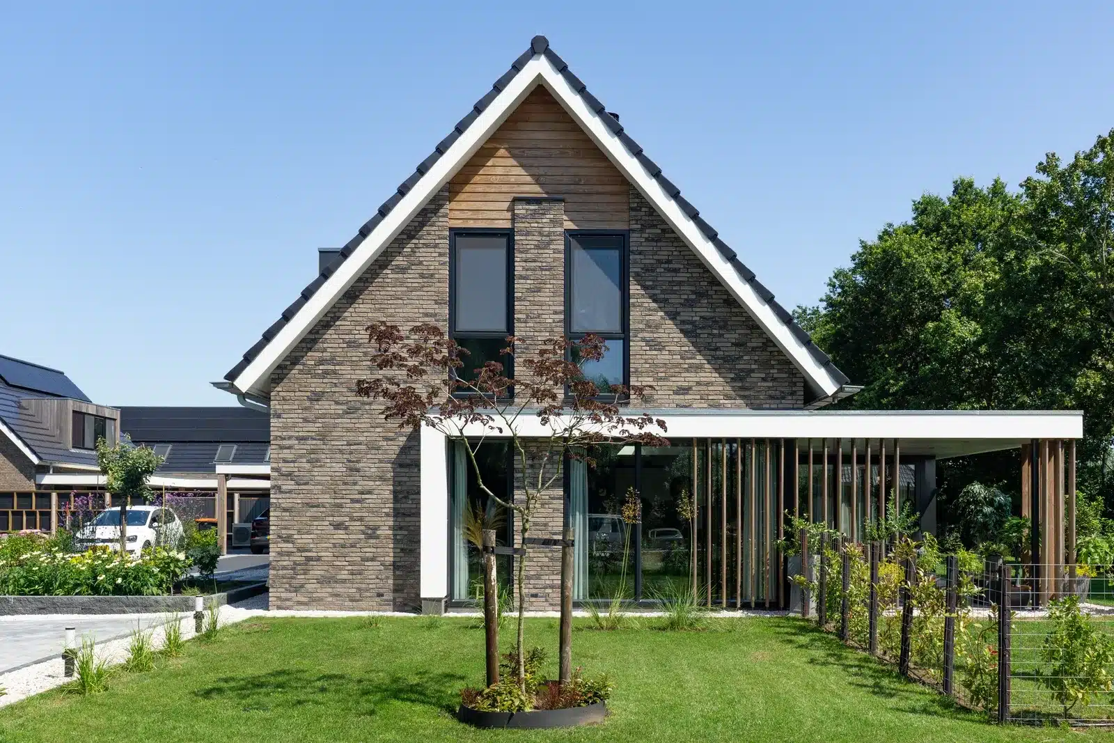 Moderne voorgevel met metselwerk en houten accenten aan de Hiethaarshoek in Wesepe.