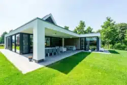 Schuin aanzicht van de moderne nieuwbouwwoning in Wesepe met grote ramen en strakke lijnen.