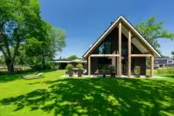 Zijaanzicht van de nieuwbouwwoning in Wesepe met royale tuin en terras.