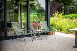 Zithoek buiten met tuinmeubels, bloemen en uitzicht op de natuur in Gorssel.