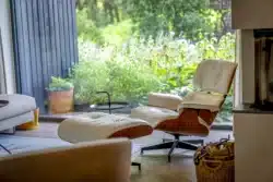 Zithoek met designstoel en uitzicht op de groene tuin van de vrijstaande woning in Gorssel.