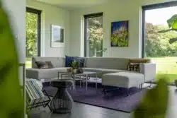 Zithoek met moderne inrichting en uitzicht op de tuin van de schuurwoning in Olst.