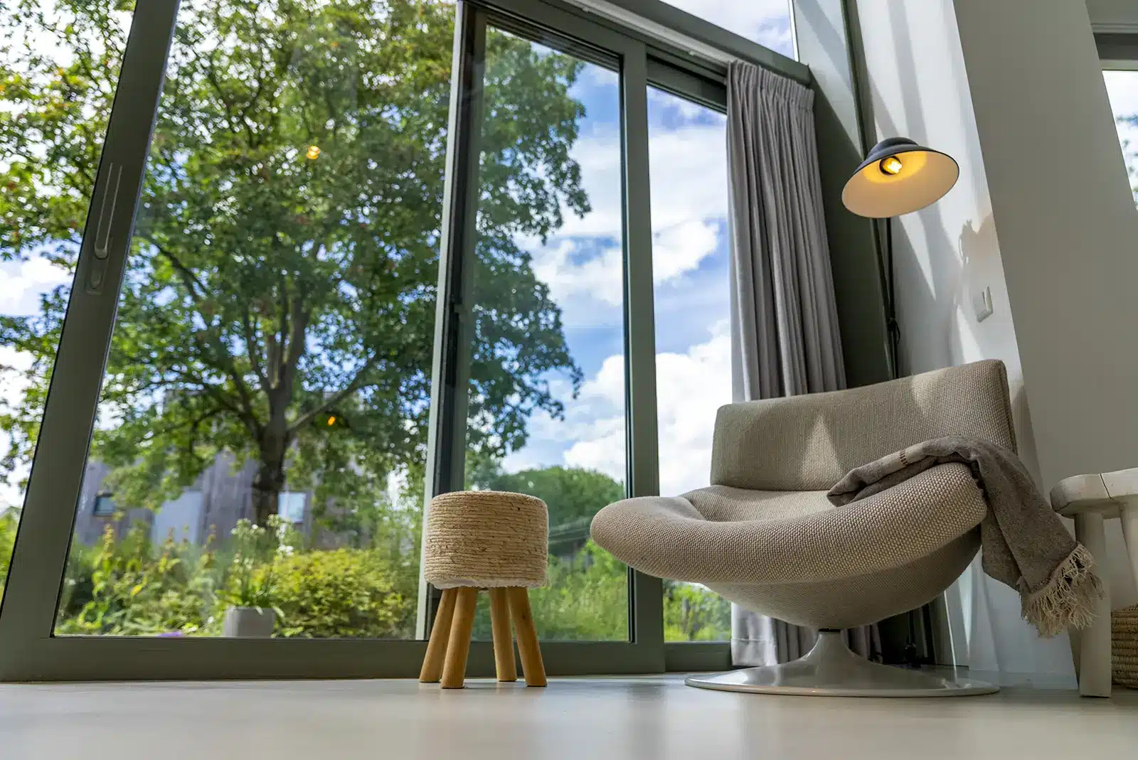 Zithoek met comfortabele stoel en uitzicht op de tuin door grote schuifpui in Deventer.