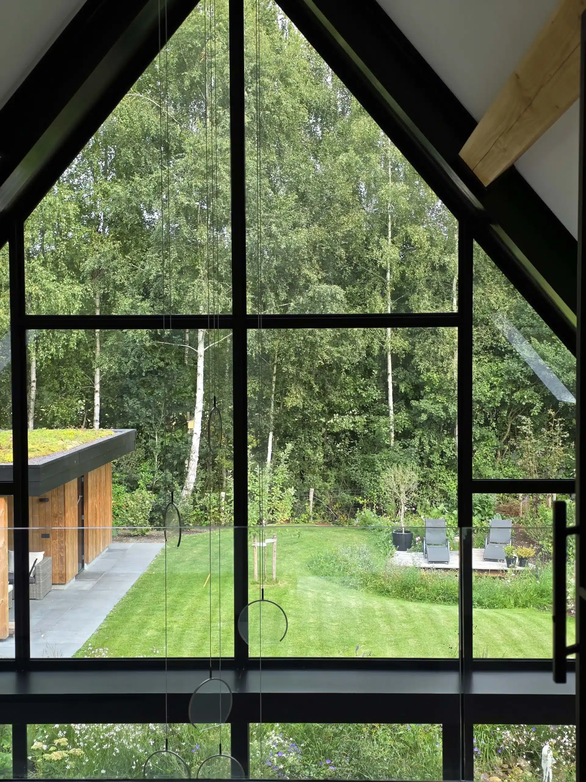 Uitzicht vanaf de vide op de tuin en het tuinhuis.